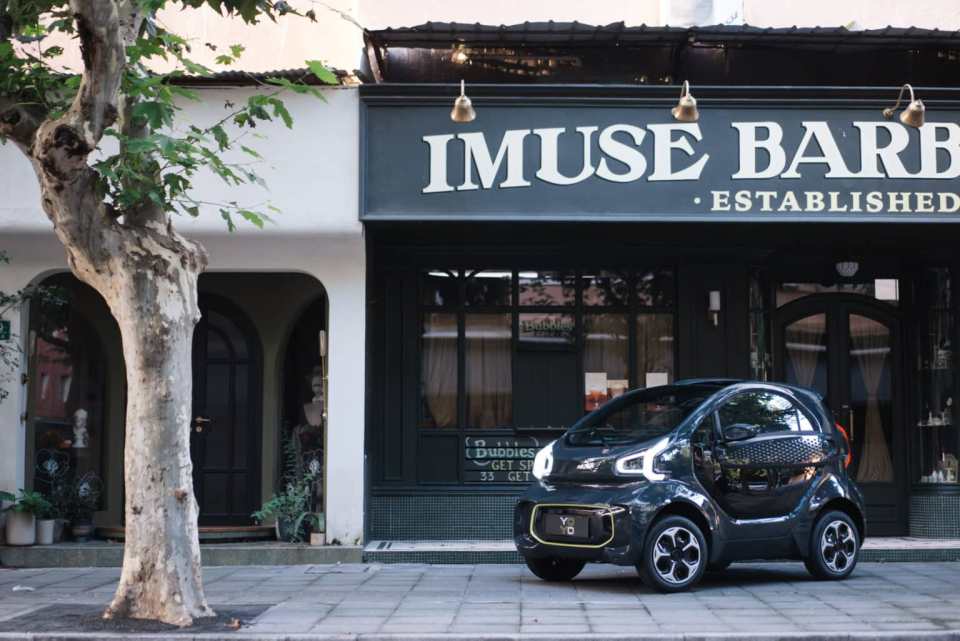 A black YOYO PRO electric car parked in front of a shop.