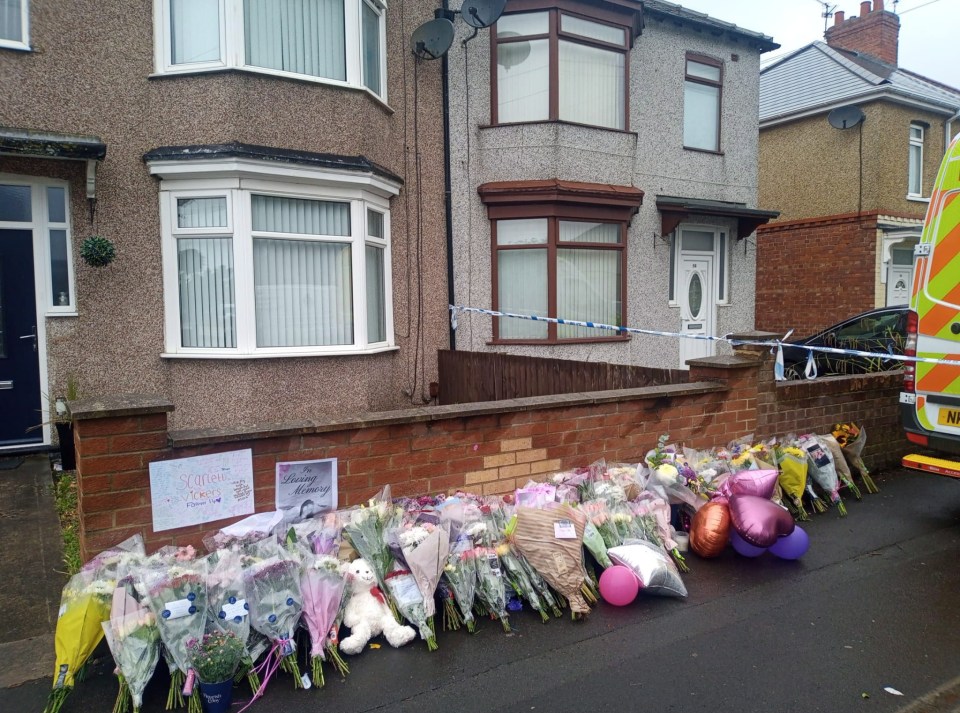 Floral tributes outside a house following the death of a 14-year-old girl.