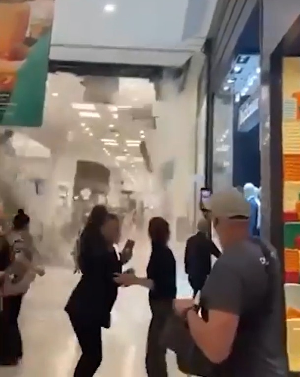 People evacuating a mall filled with smoke.