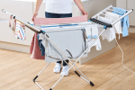 Person loading clothes onto an electric heated clothes airer.