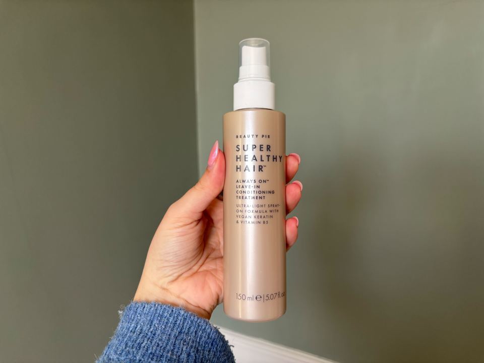 Hand holding Beauty Pie Super Healthy Hair leave-in conditioning treatment spray.