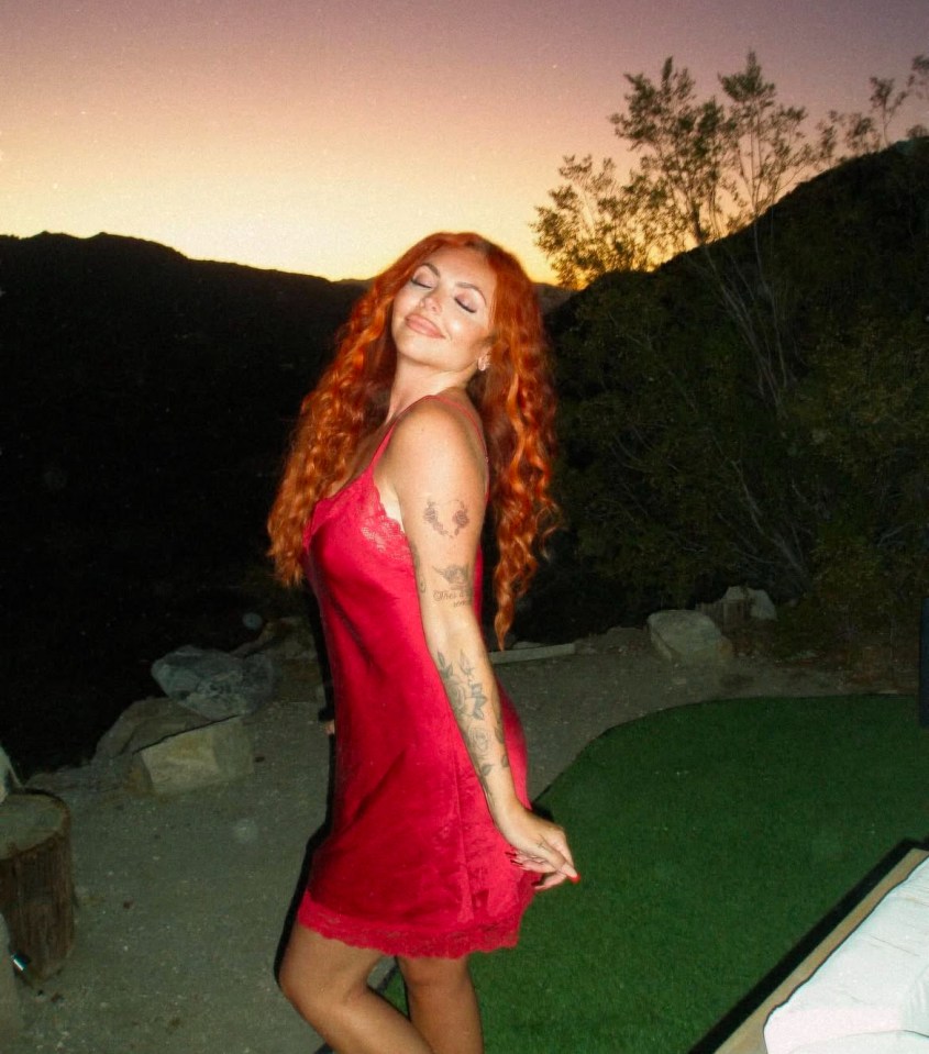 Woman in red slip dress at sunset.
