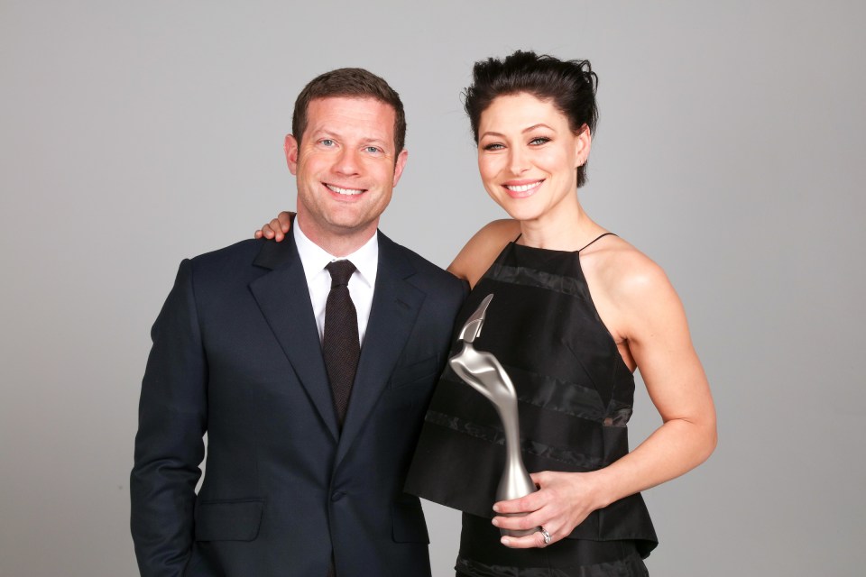 Two people holding a BRIT Award.