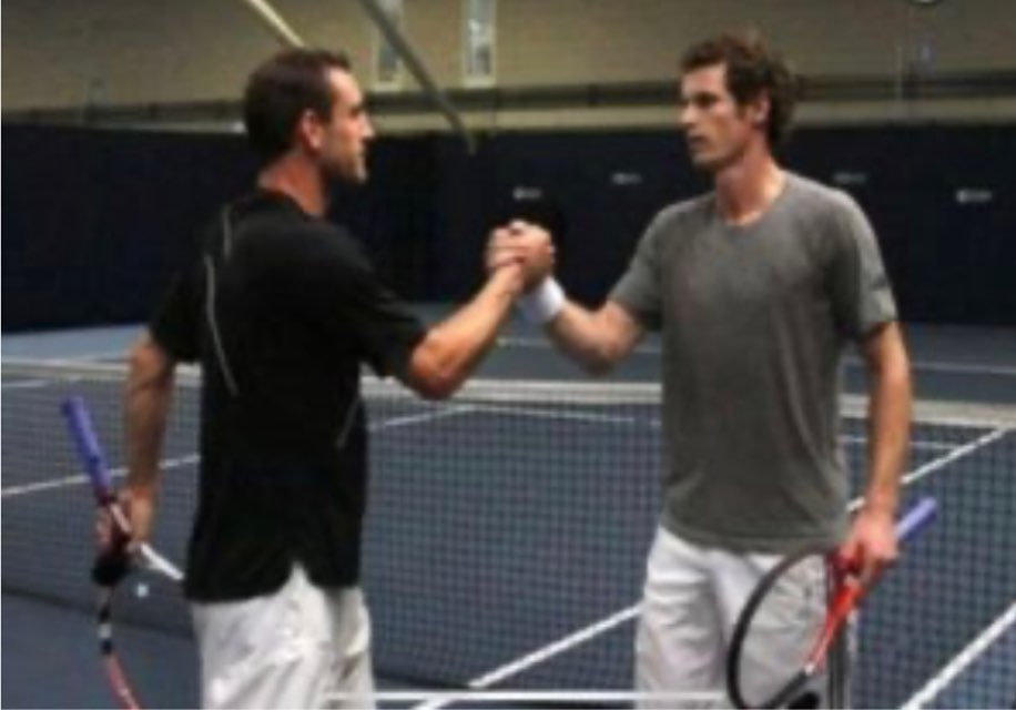 Two tennis players shaking hands on a court.