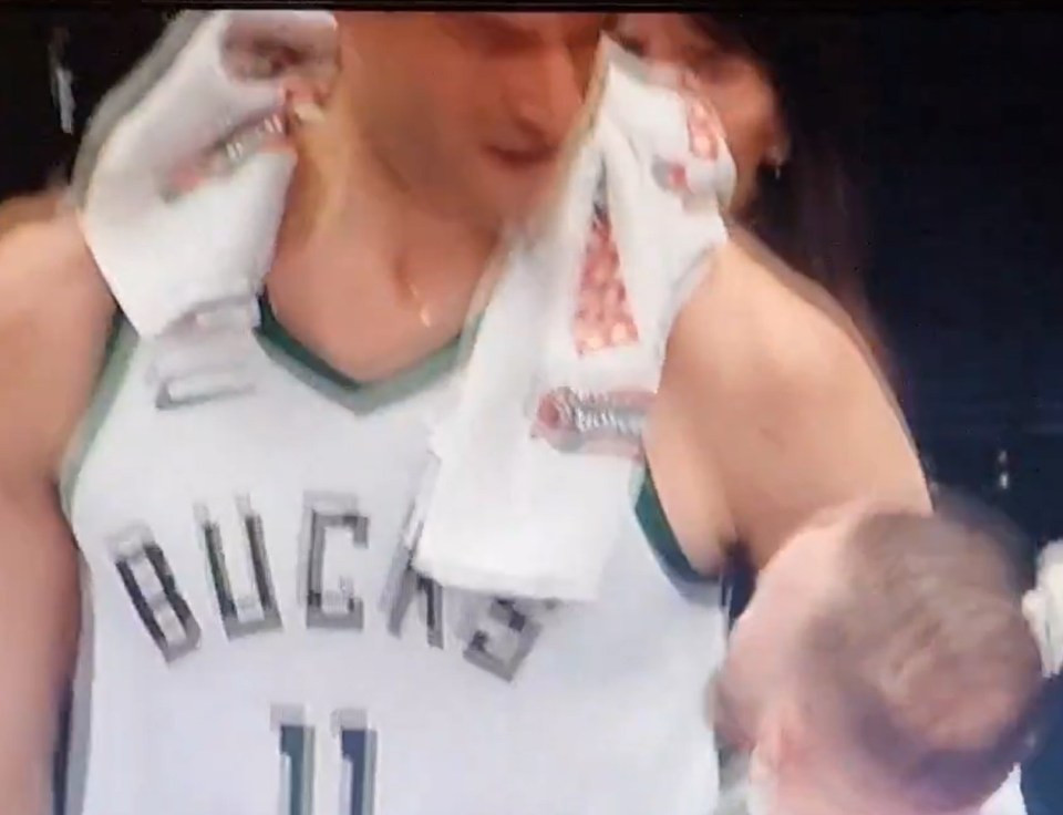Milwaukee Bucks player #11 being embraced.