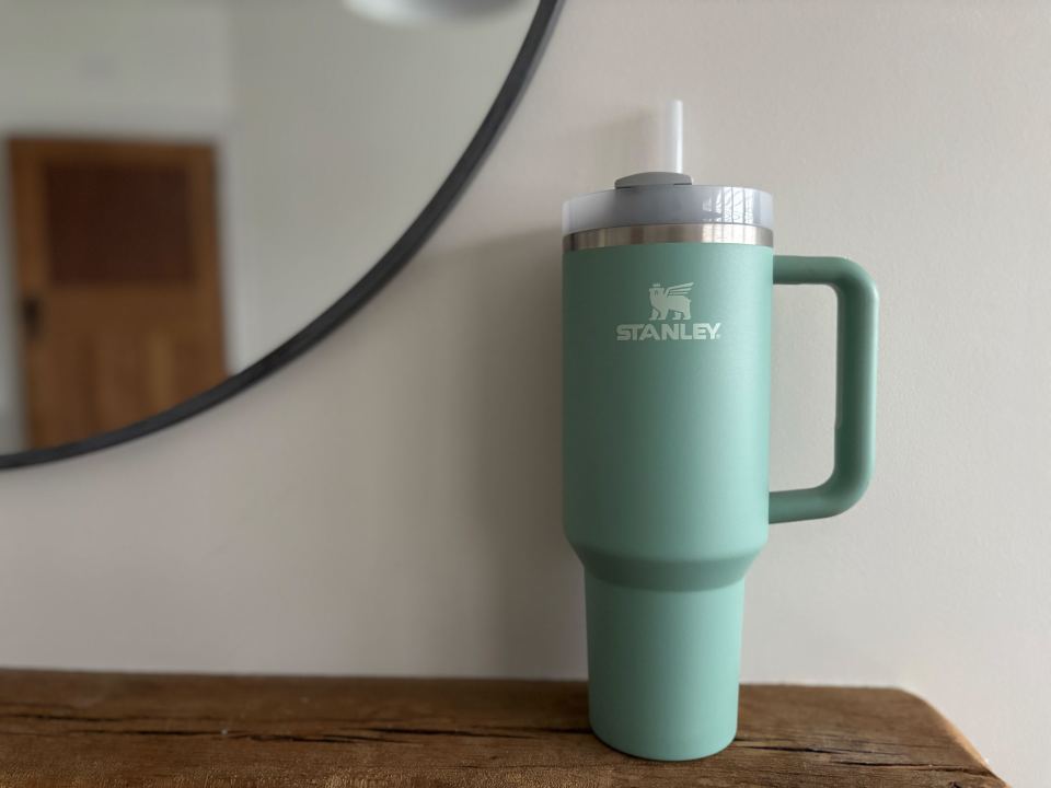 Sage green Stanley mug with handle and straw.
