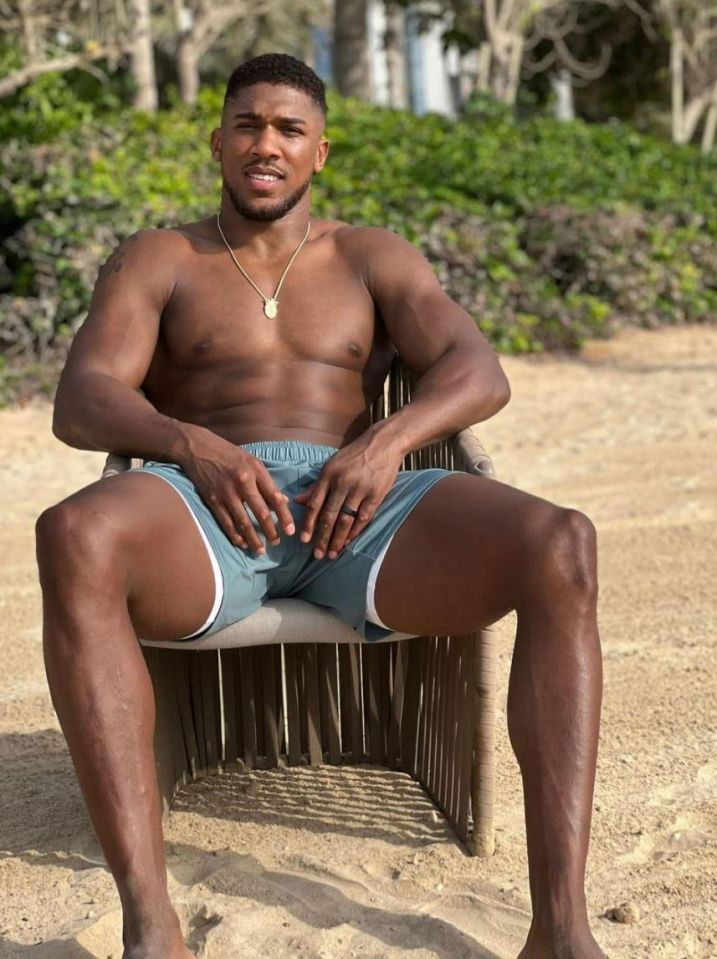 Anthony Joshua sitting on a chair on the beach.