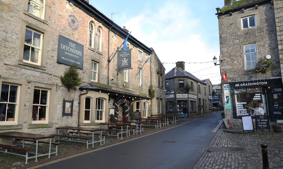Grassington village street scene with The Devonshire Inn and other shops.