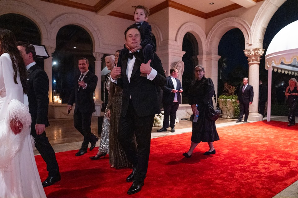 Elon Musk carrying his son on his shoulders at a New Year's Eve party.