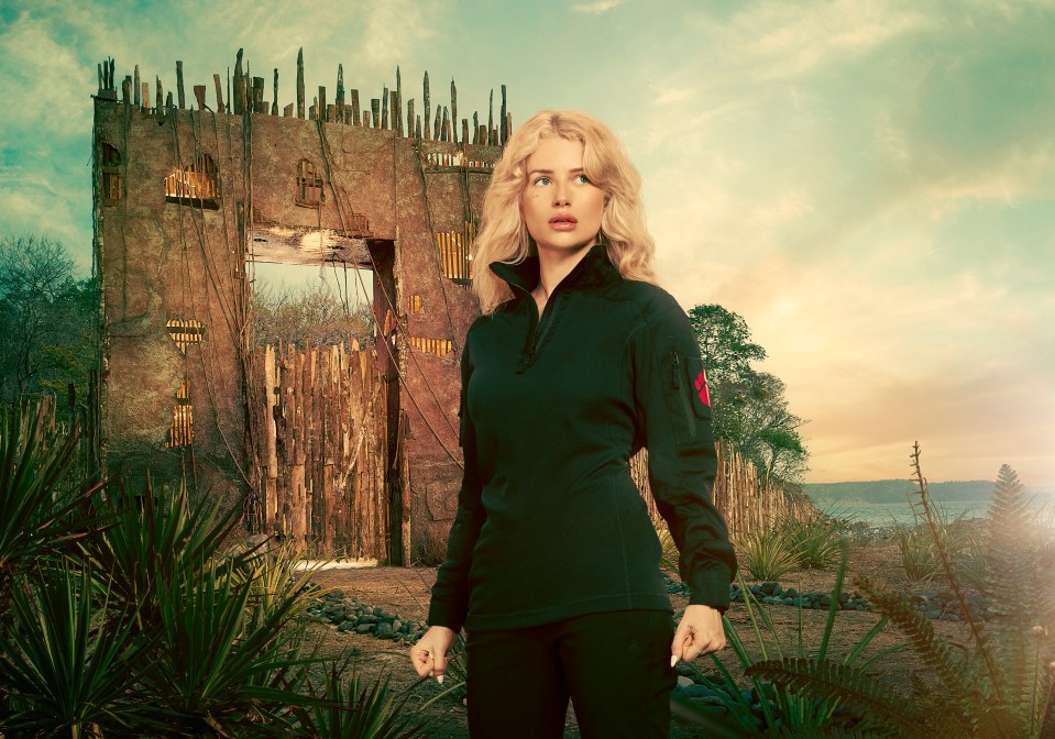Lottie Moss in a dark top stands before a dilapidated wooden gate.