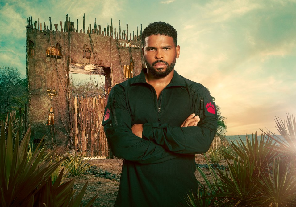 Kola Bokinni, arms crossed, standing before a dilapidated gate.