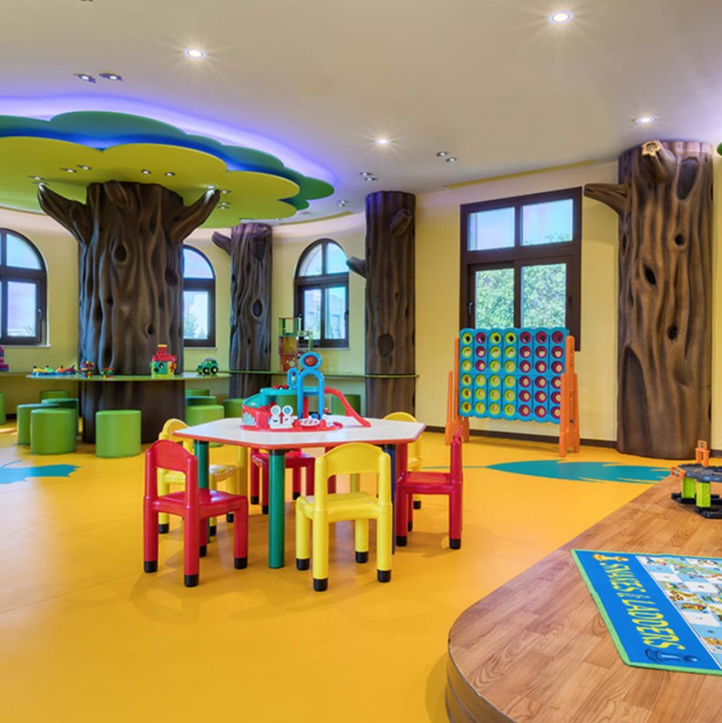 Children's play area with colorful furniture and tree-themed decor.