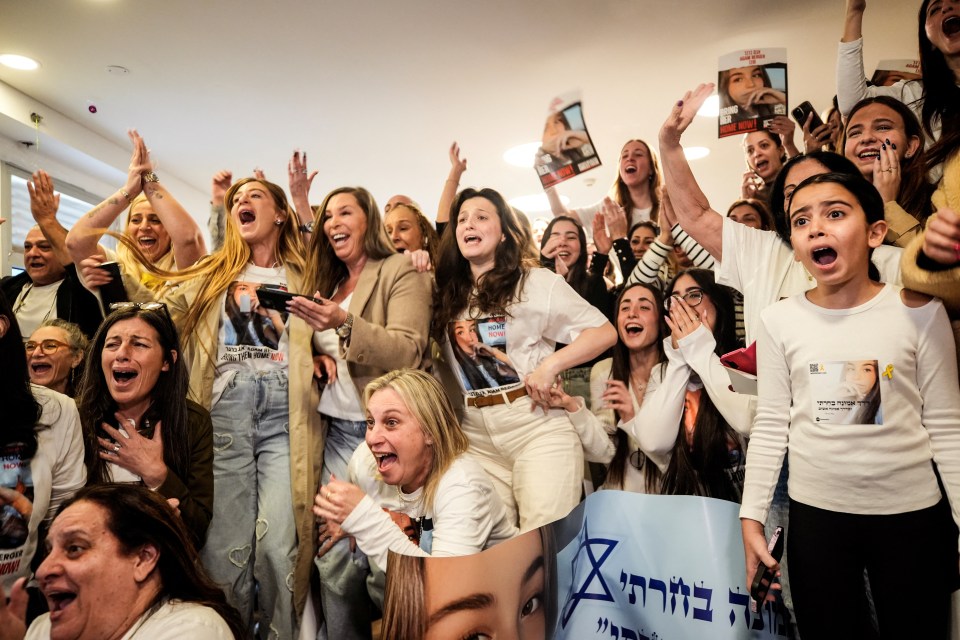 Family and friends react joyfully to the release of an Israeli hostage on a screen.