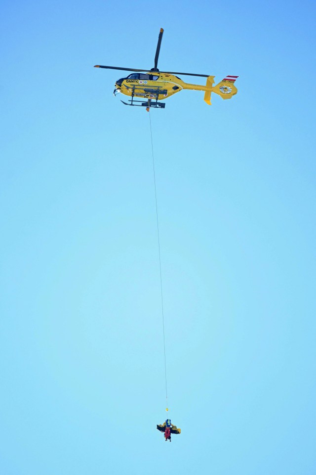 Helicopter airlifting skier.