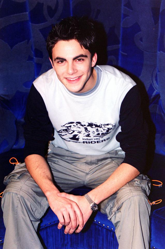 Sam Bloom, seated, wearing a baseball shirt and cargo pants.