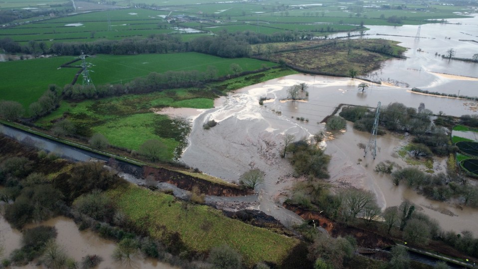 Aerial view of flooded fields and a collapsed canal bank.