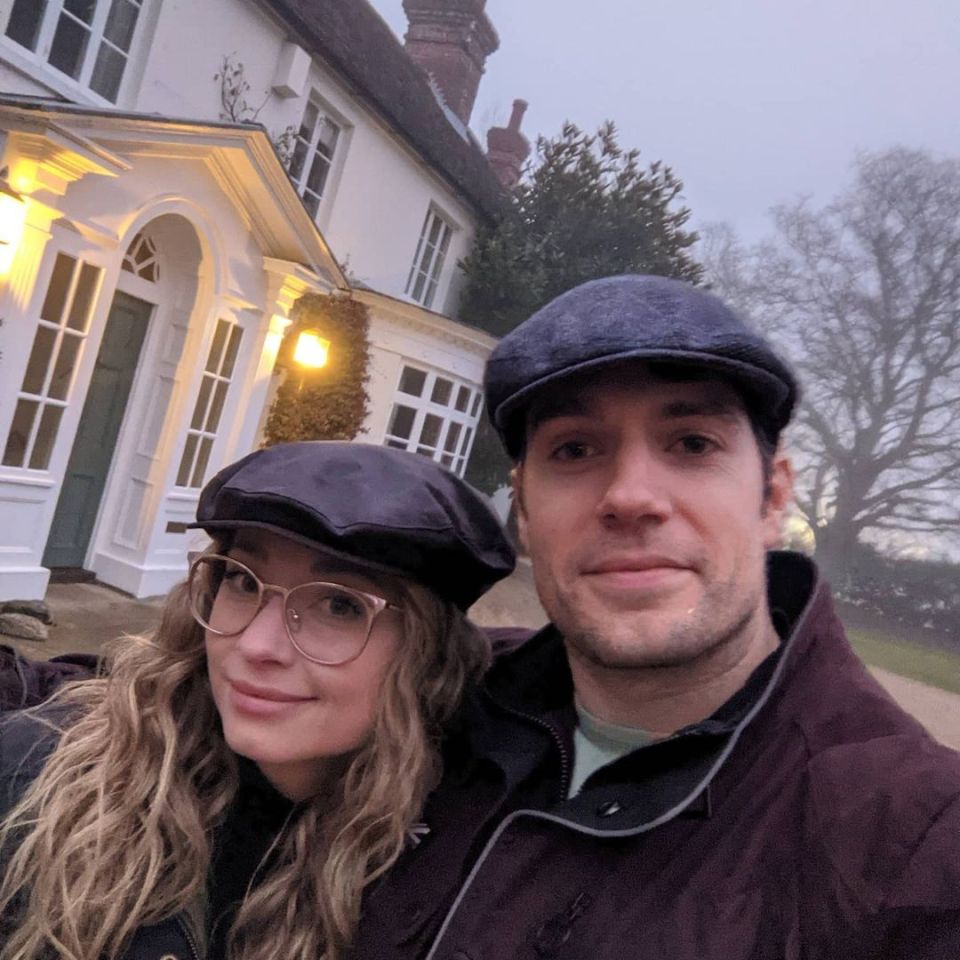 Henry Cavill and his girlfriend in front of a house.