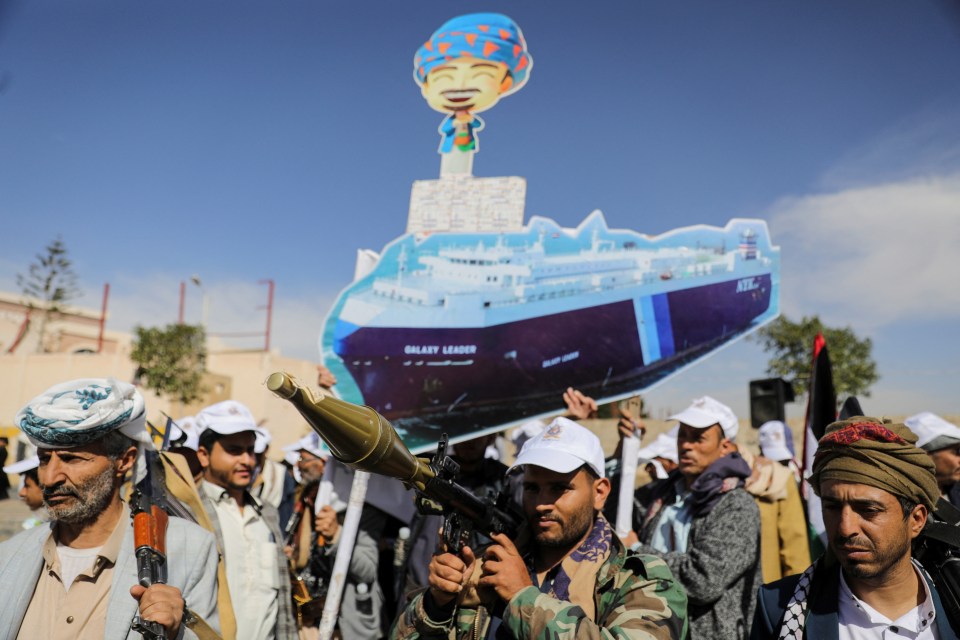 Houthi followers in Sanaa, Yemen, at a parade holding a cutout of the Galaxy Leader cargo ship they seized.