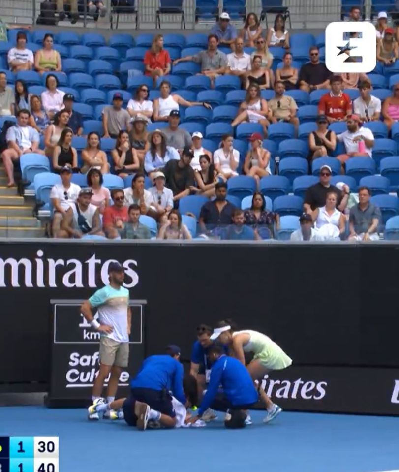 Tennis player assisting a ball kid.