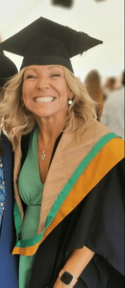 Smiling woman in graduation gown and cap.