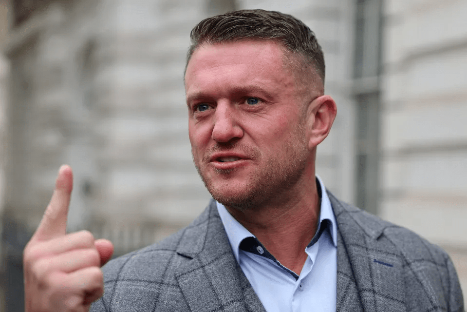 Man in suit jacket gesturing with his index finger.