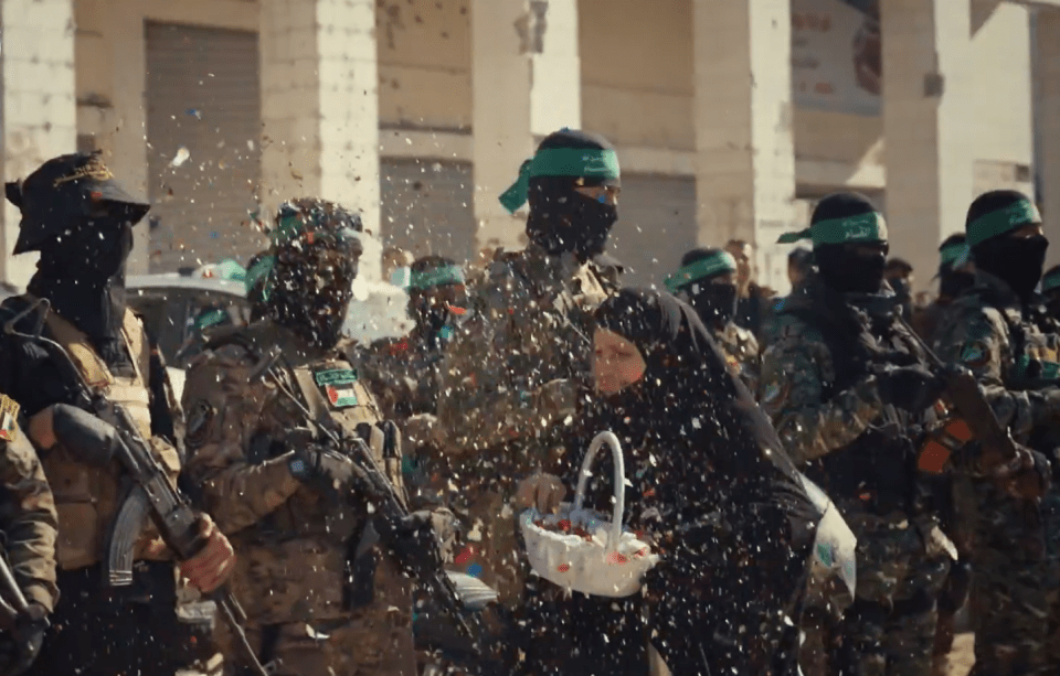 Armed soldiers throwing confetti on a woman holding a basket.