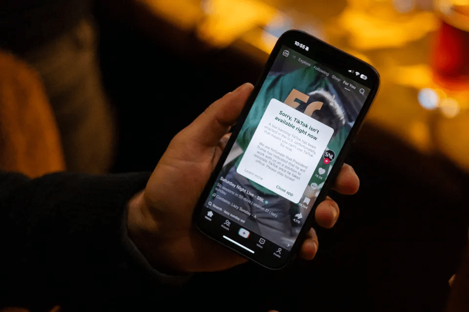Smartphone displaying a TikTok error message stating the app is unavailable in the U.S. due to a law banning it.