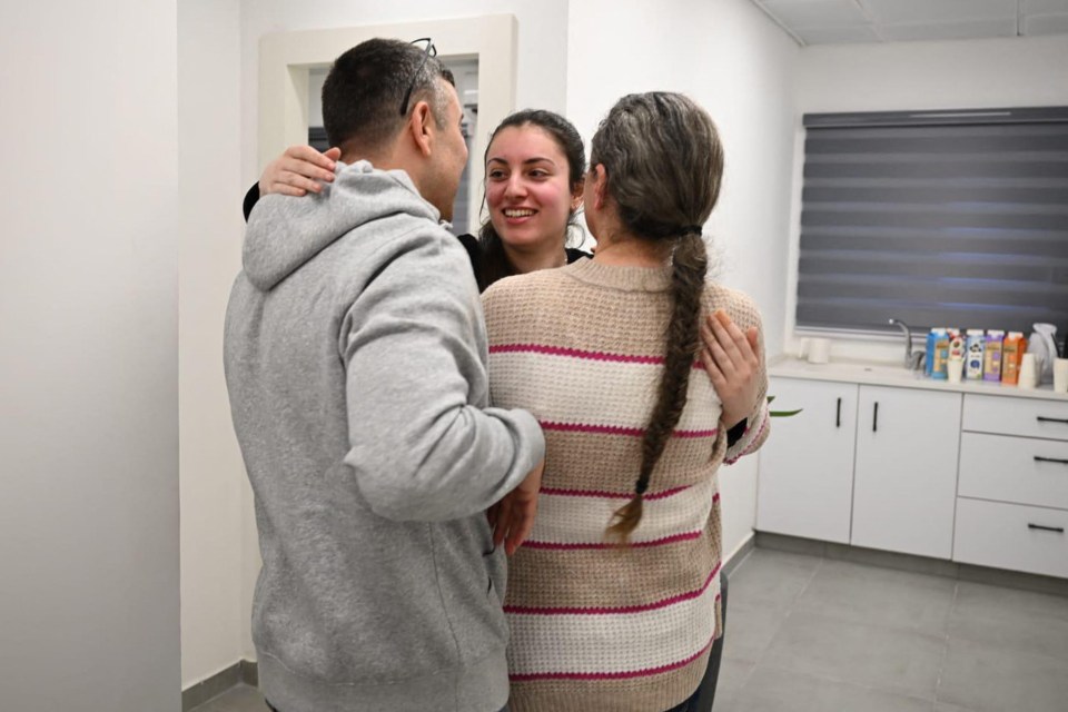 Three people embracing.