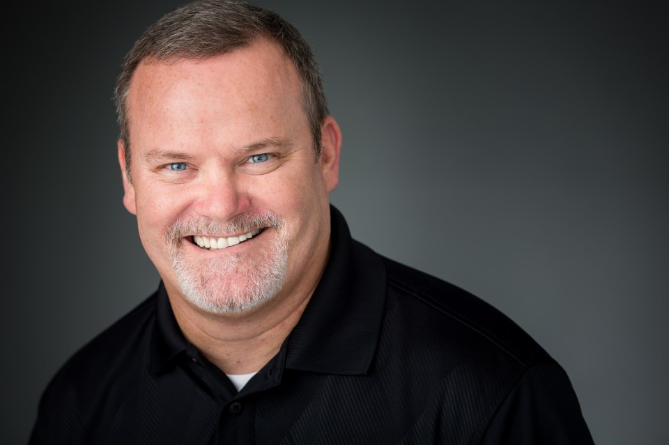 Headshot of a smiling man.