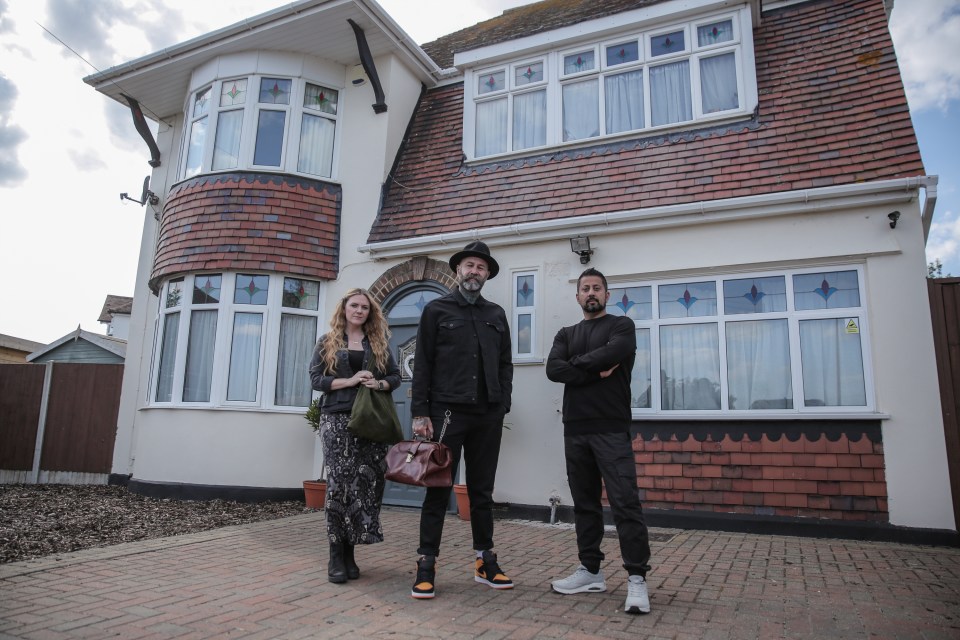 Three people standing in front of a house.