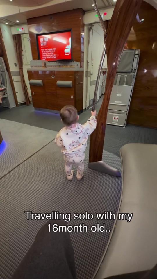 Toddler standing in first-class airplane cabin.