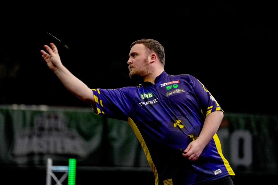 Luke Littler throwing a dart during a darts match.