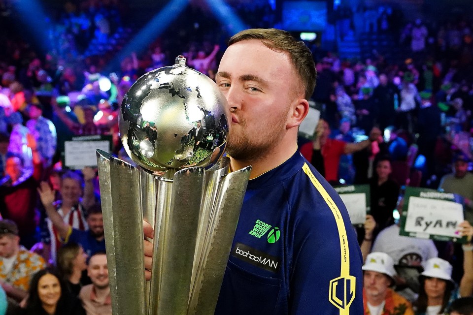 Luke Littler kisses the Sid Waddell Trophy after winning the Paddy Power World Darts Championship.