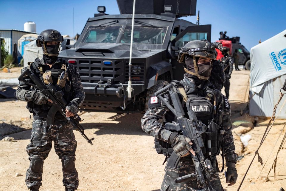 Syrian Kurdish Asayish security forces inspecting tents at a refugee camp.