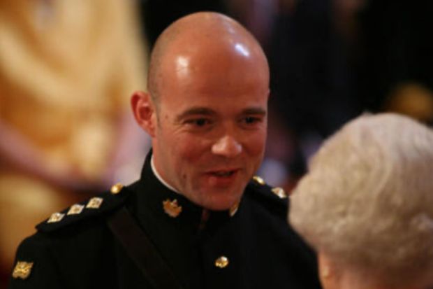 Close-up of a bald man in military uniform.