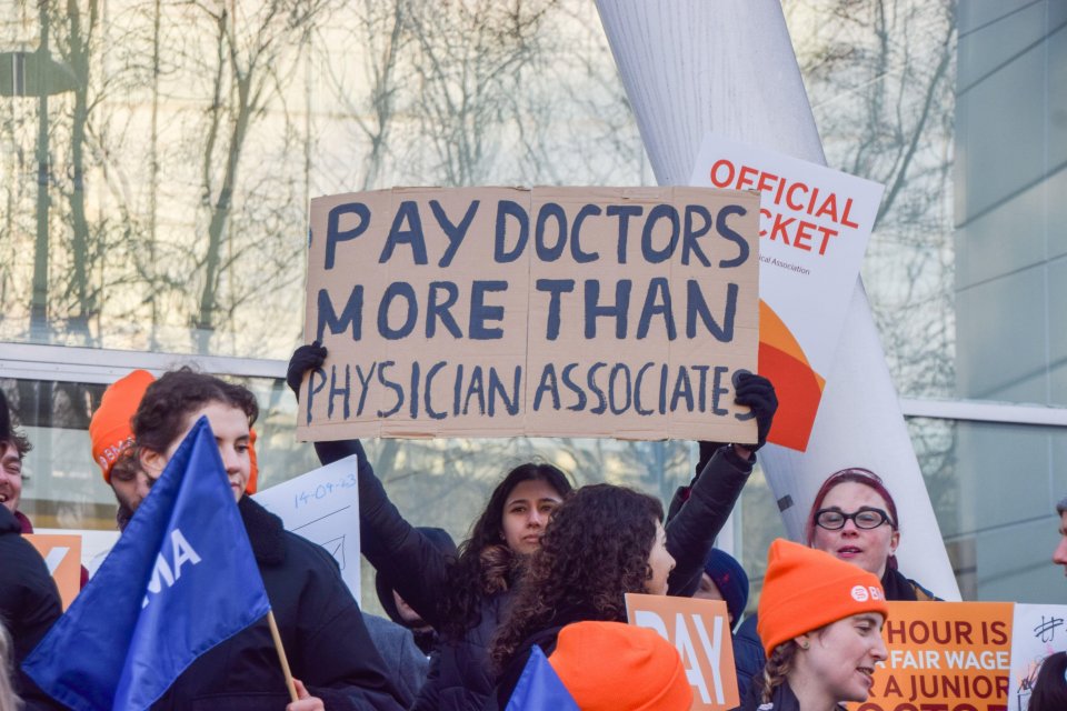 Junior doctors picket outside a hospital, demanding higher pay.