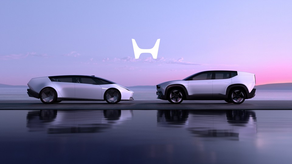 Two Honda concept cars parked by the water.