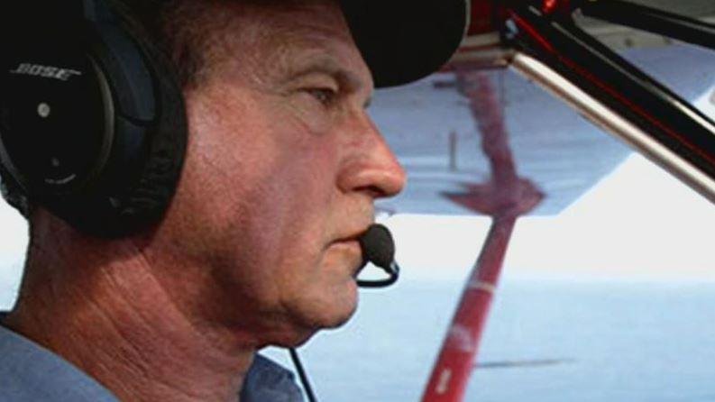 Pilot wearing headset in cockpit.