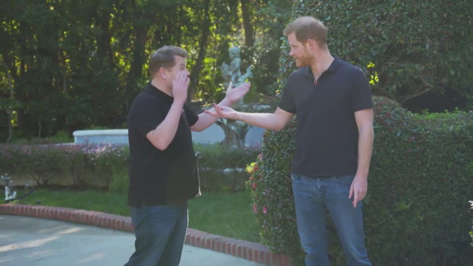 Prince Harry and James Corden talking outdoors.