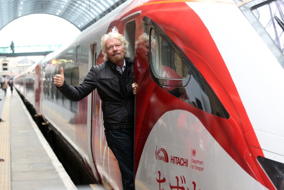 Richard Branson giving a thumbs-up next to a Virgin Azuma train.