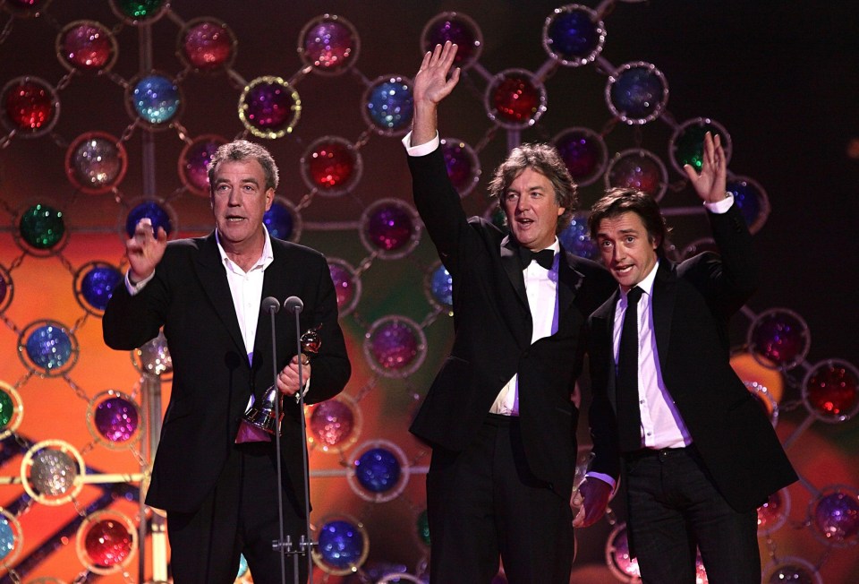 Top Gear presenters James May, Richard Hammond, and Jeremy Clarkson accepting an award.