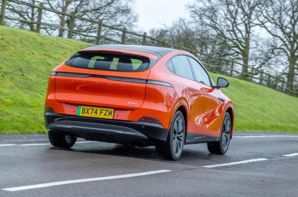 Orange Xpeng G6 electric car driving on a road.