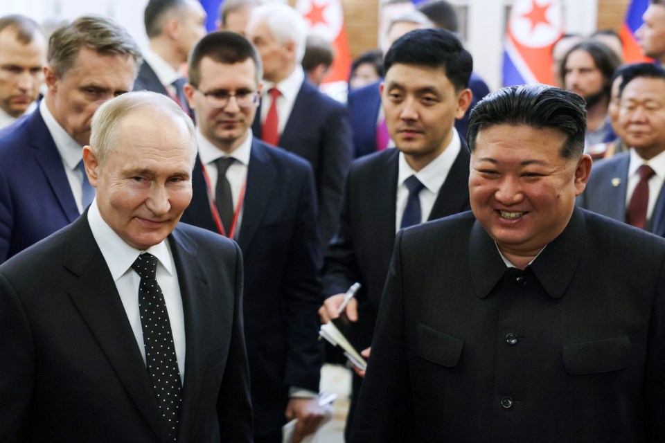Vladimir Putin and Kim Jong Un smiling together.