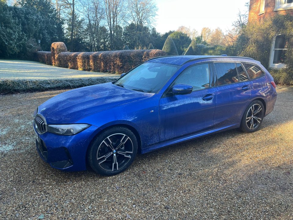 Blue BMW station wagon parked in a driveway.