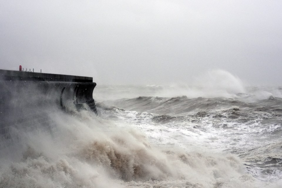Waves crashing against a seawall in Dover, Kent during a storm.