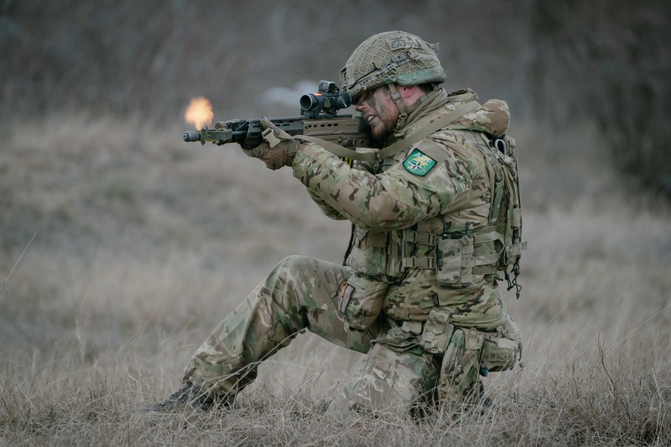 British soldier firing a rifle during a military exercise.
