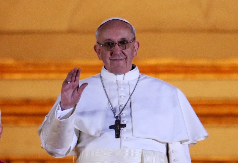 Pope Francis waving from a balcony.