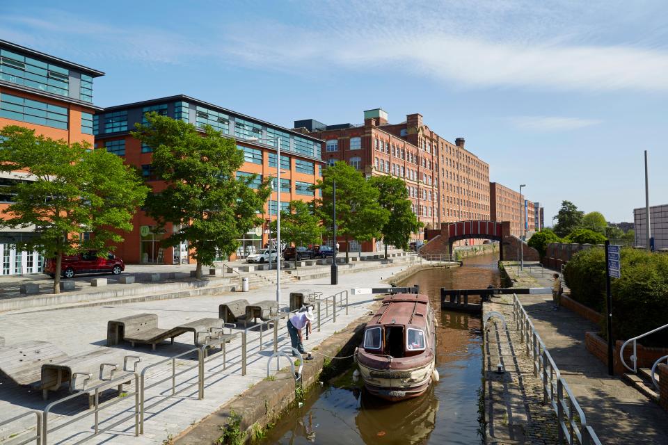 Royal Mills in New Islington, Manchester, with a narrowboat on a canal.