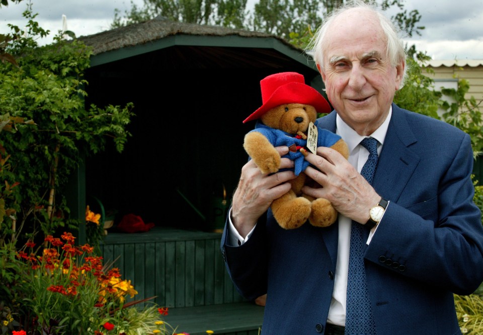 Michael Bond holding a Paddington Bear.