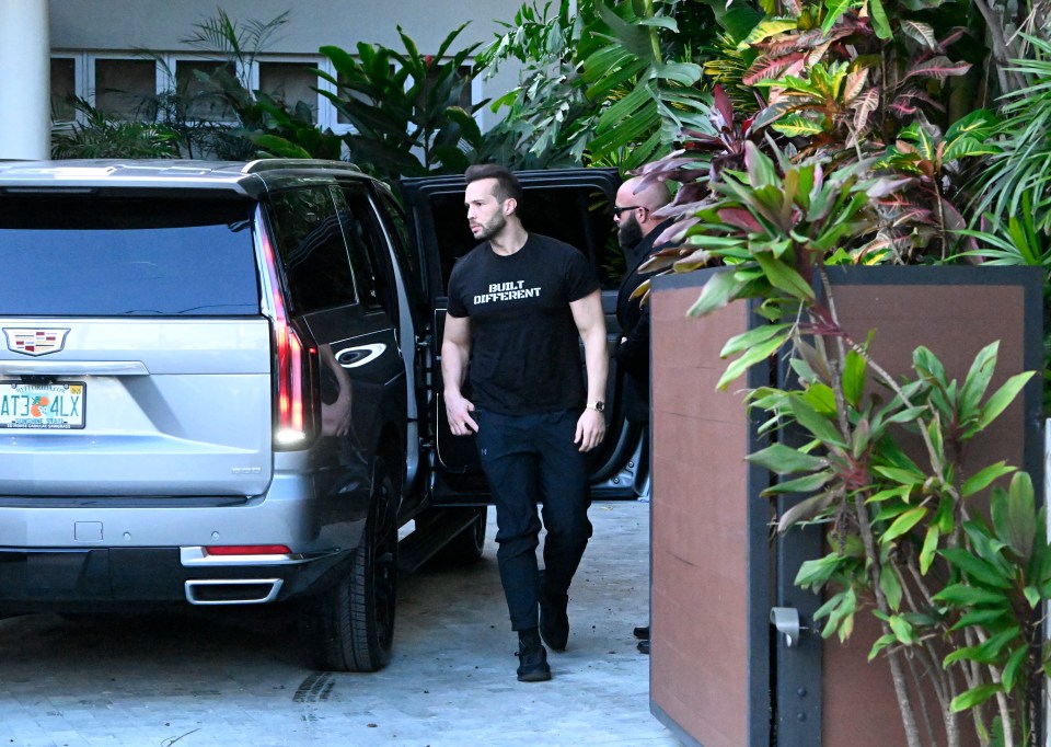 Andrew Tate exiting a vehicle.